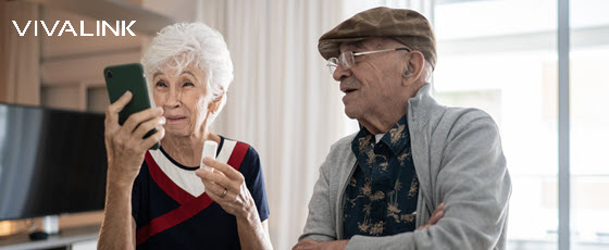 Family caregiver using wearable technology like a smartwatch and health monitor to track their loved one's health data in a hospital-at-home model setting.